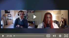 A paused video call screen showing two people in separate locations, with one person on each side of the split screen, engaged in conversation.