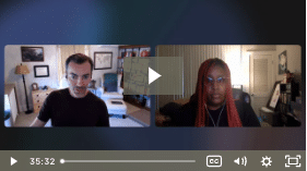Two people are engaged in a video call; one with short hair in a light room, the other with red braids in a dark room. They seem focused.