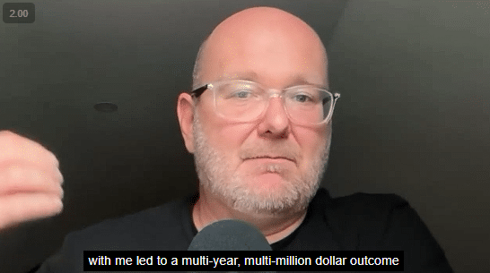 Bald man with glasses and light stubble looking at the camera indoors.